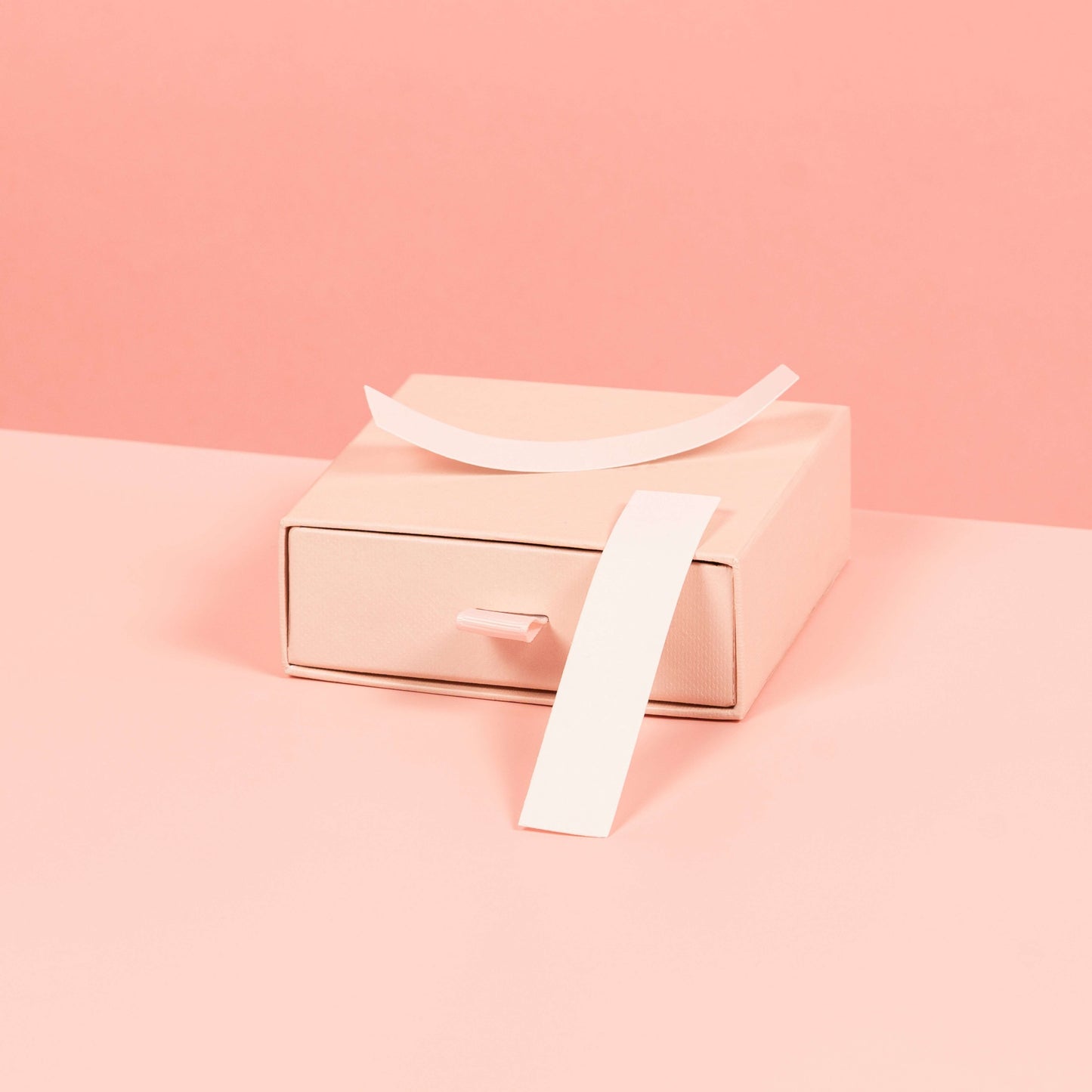 A stylized photo of Brelese Clothing Tape on a pink background.