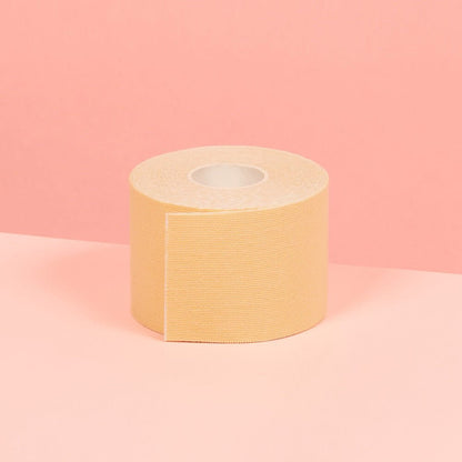 5 cm beige double sided boob tape is showcased on a pink table.