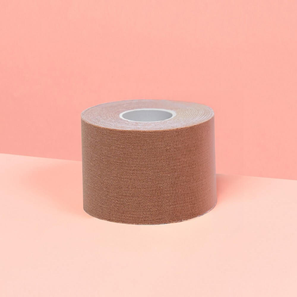 Smaller 5cm chocolate boob tape is showcased on a pink table.