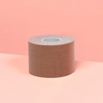 Smaller 5cm chocolate boob tape is showcased on a pink table.