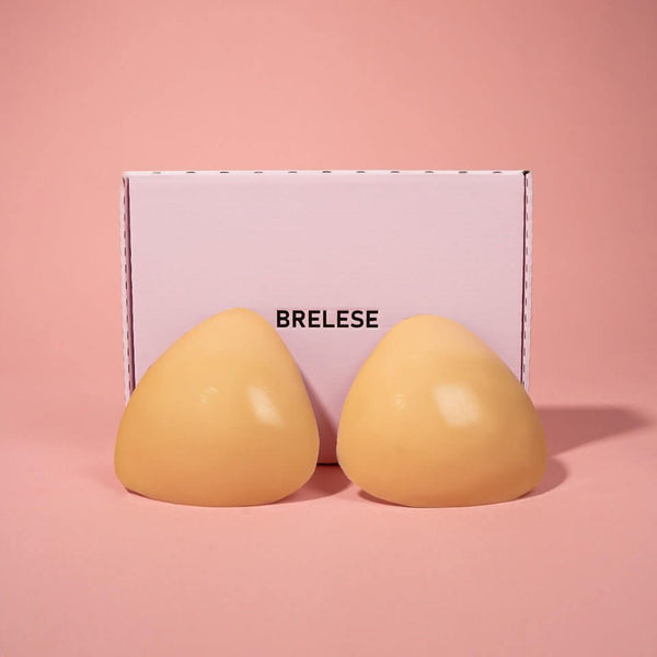 Double-stick push-up bra inserts in Nude colour next to the pink Brelese box.