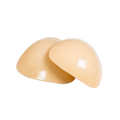 Beige sticky inserts stacked on top of each other in front of a plain white background, showcasing the sticky insert material up close.